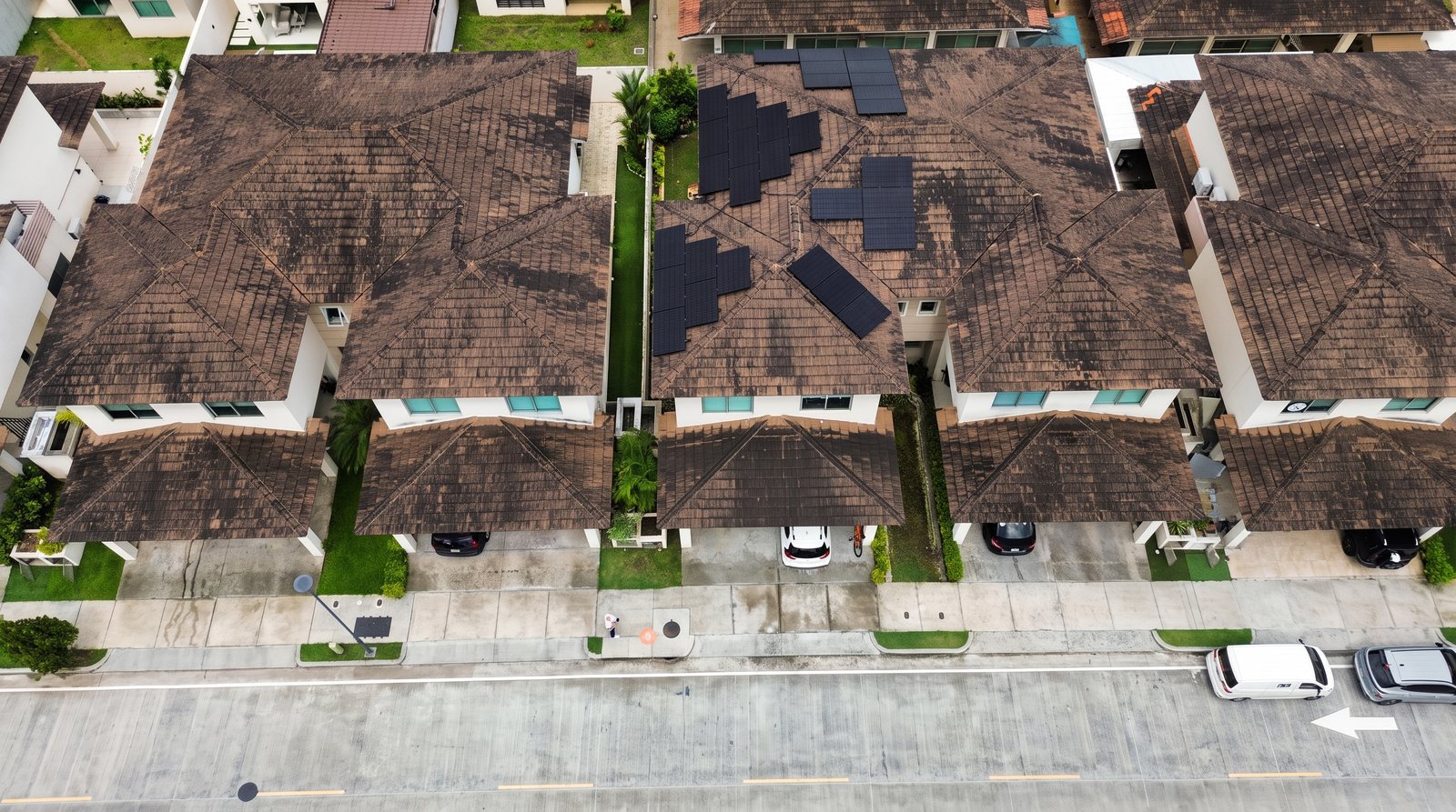 Paneles solares sobre los techos de una hilera de casas residenciales, vista de dron