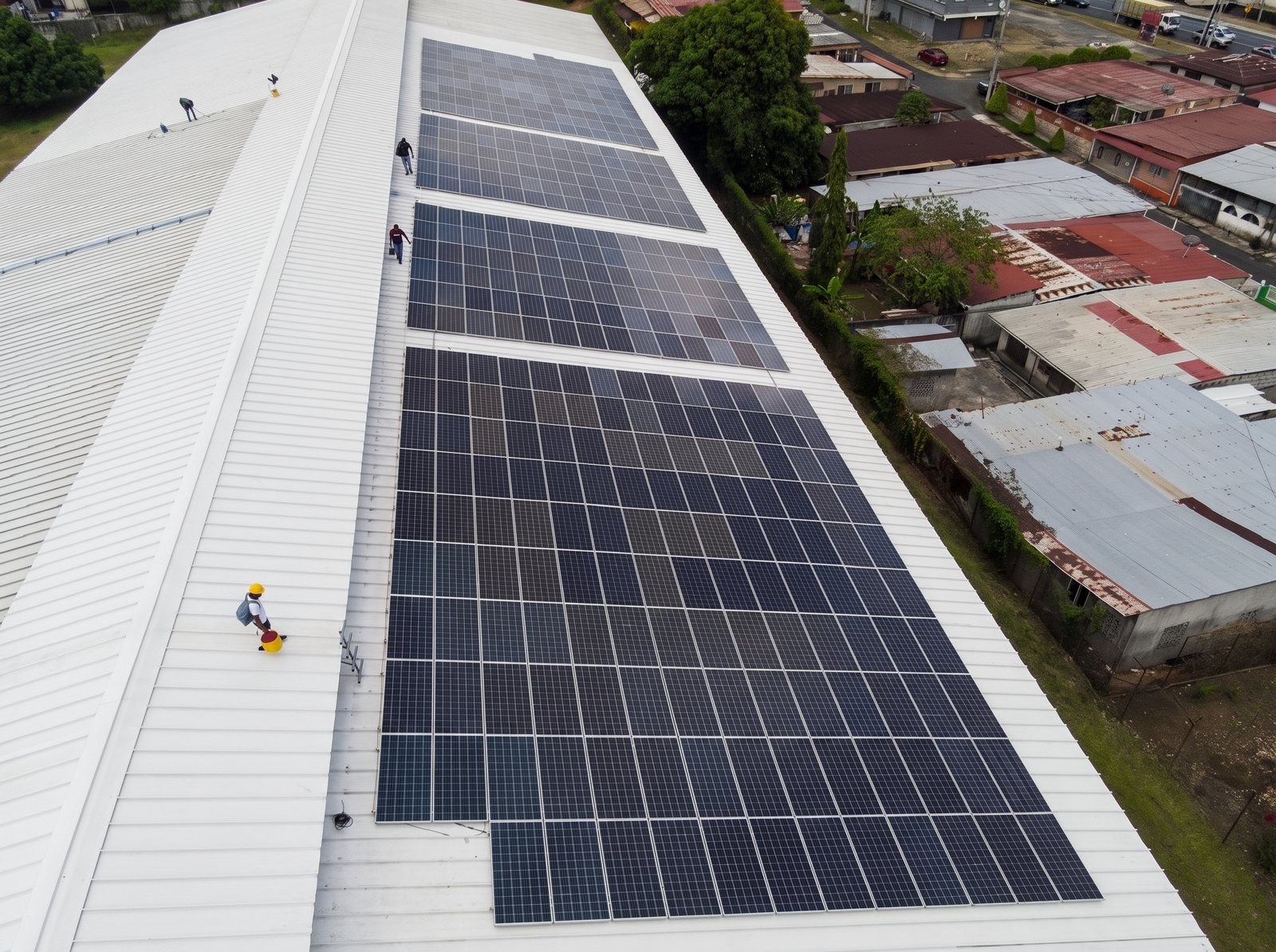Técnico de GreenTec trabajando junto a paneles sobre techo metálico